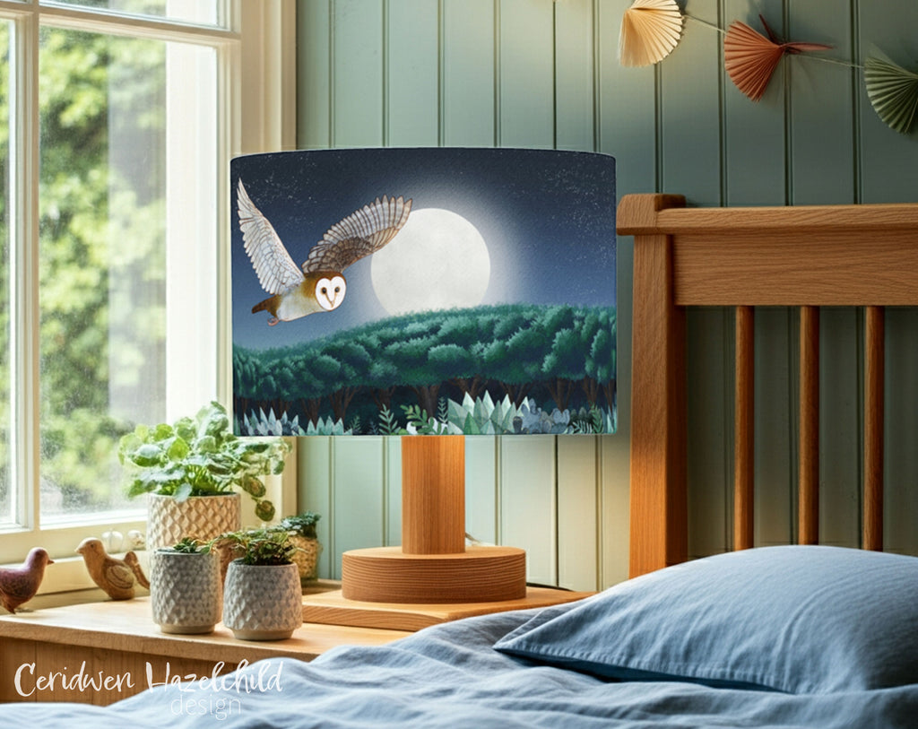 An owl lampshade on a bedside lamp next to a bed in a childrens bedroom.