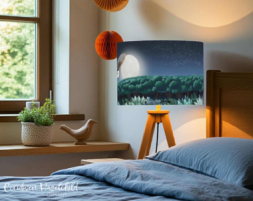 Cozy bedroom with a bedride lamp with a lampshade featuring an owl flying over a forest at night 