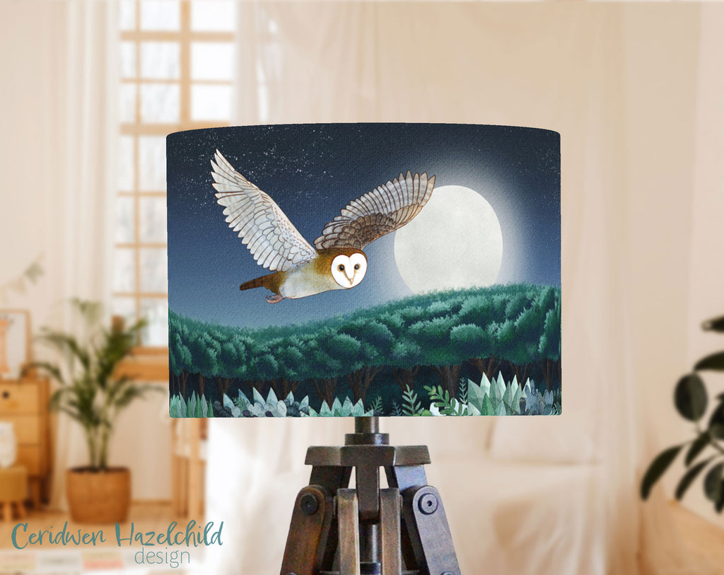 Lampshade with barn owl design against a night sky with moon and trees, in a childrens bedroom.