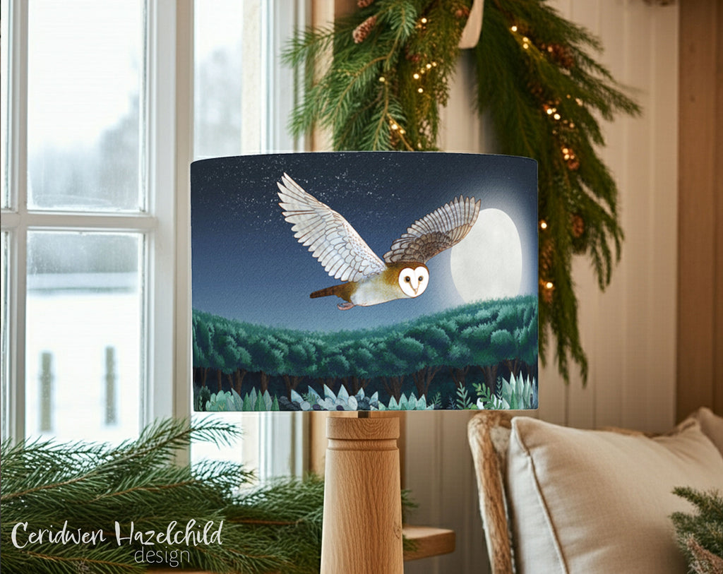 Decorative lampshade with an owl design hanging above a table with Christmas decorations.