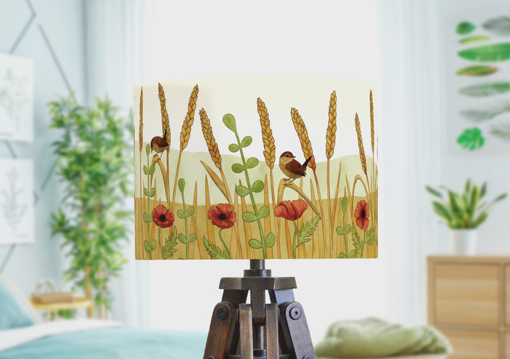 A rotating video of a handmade bird lampshade with a panoramic illustration of wrens in a wheat feild with poppies.