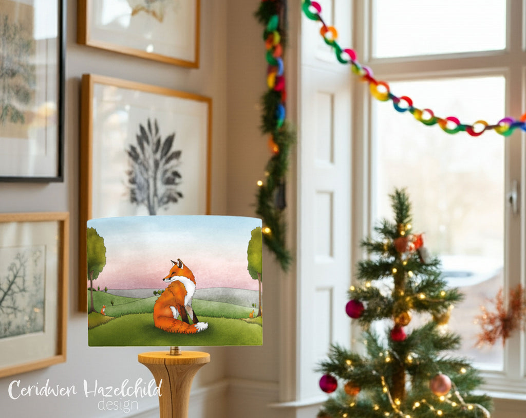 Decorative wall art of a fox in a field with a Christmas tree and garland in the background.