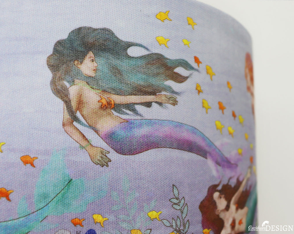 Detail of a Mermaid Lampshade illustrared by Ceridwen Hazelchild, showing an Indian mermaid swimming amongst orange fish.