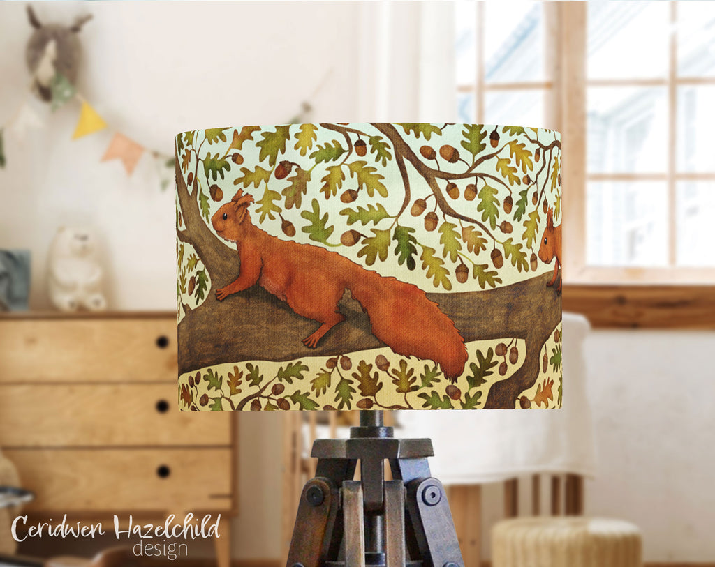 A woodland nursery with a drum lampshade, featuring and illustration by Ceridwen Hazelchild of a red squirrel in a tree.