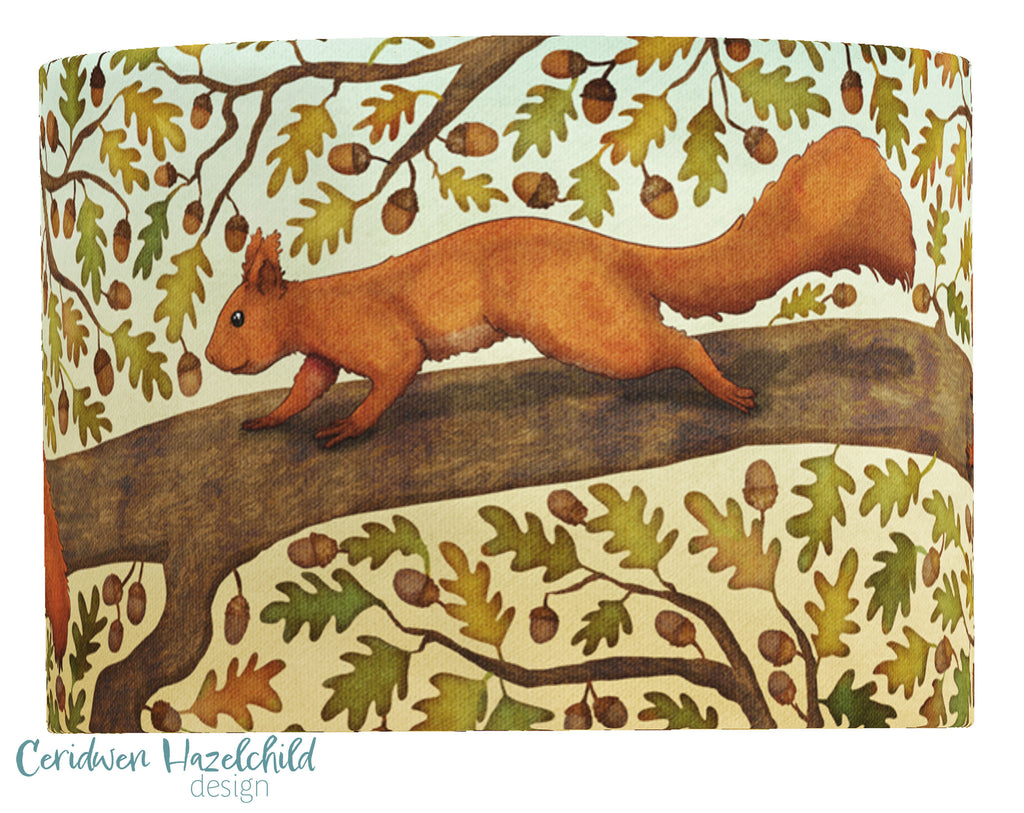 A cutout of a lampshade featuring a print of a red squireel in an oak tree, by Ceridwen Hazelchild.
