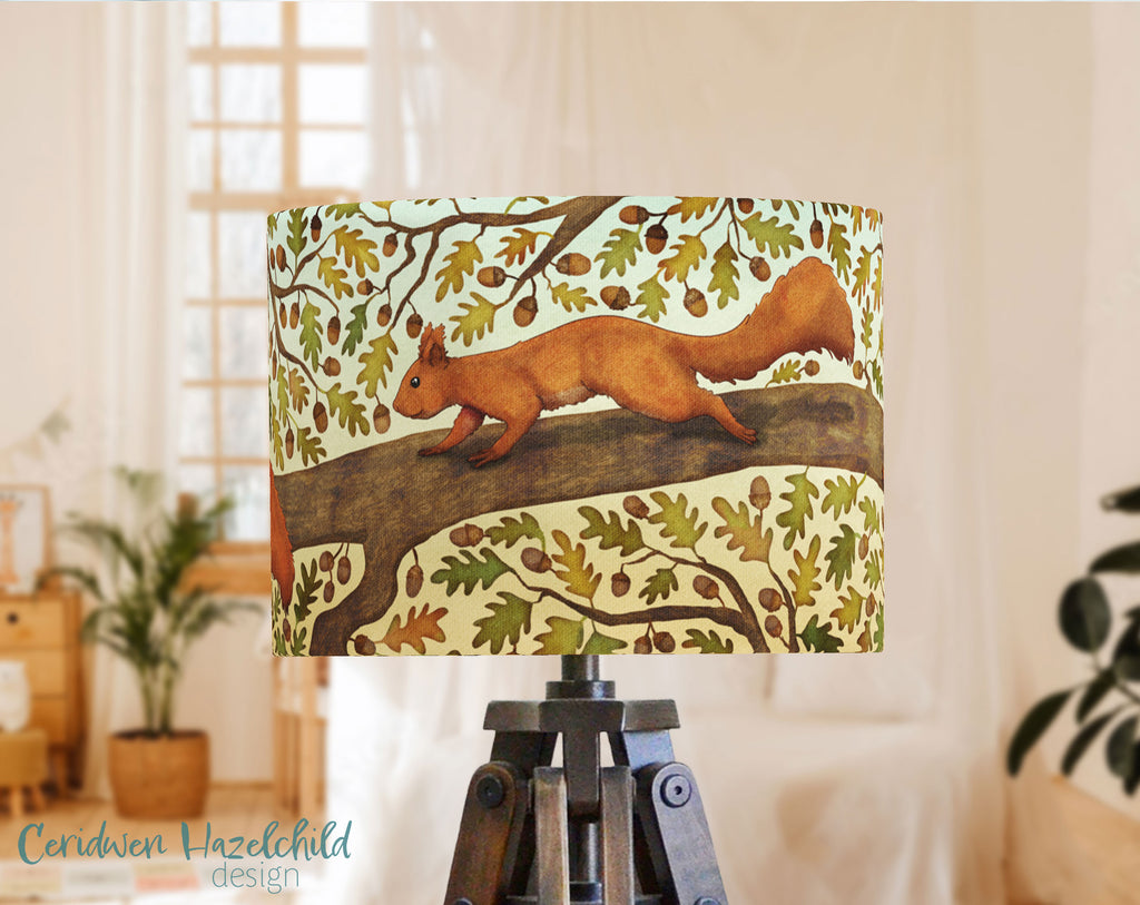 A handmade lampshade with an illustration of a red squirrel in an oak tree, by Ceridwen Hazelchild.