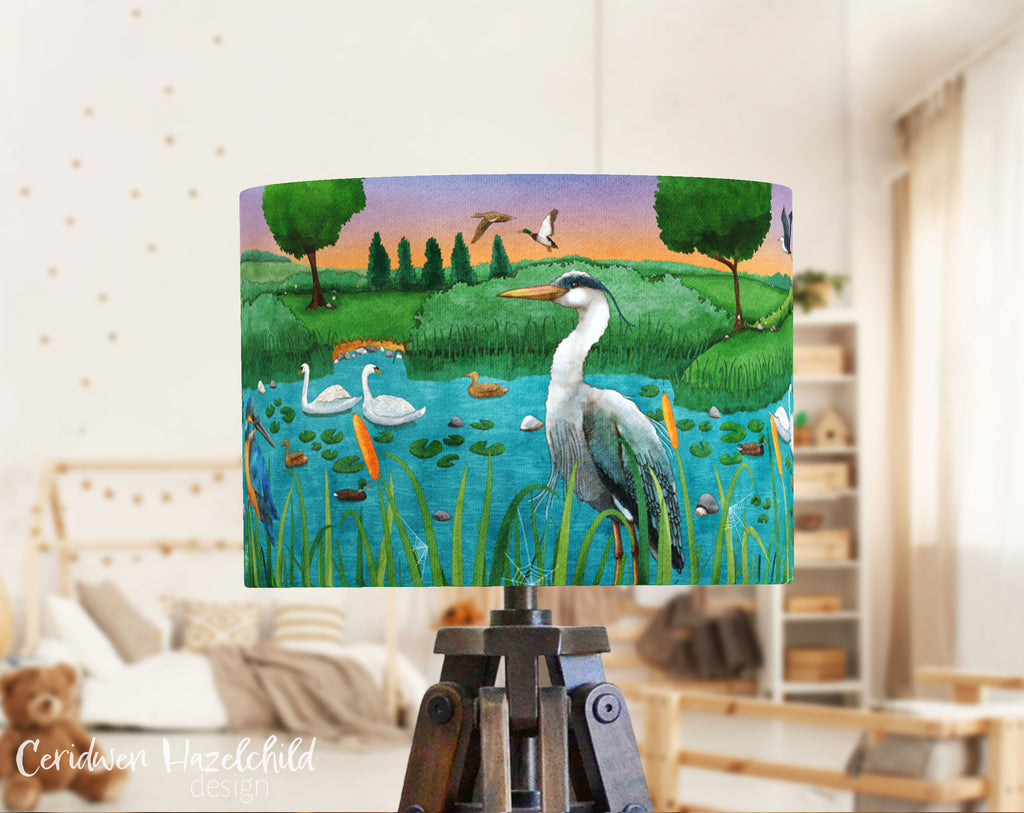 A child's bedroom with a lampshade featuring an illustration of a heron in a lake, by Ceridwen Hazelchild.